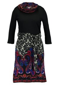Abito lungo nero a maniche lunghe con un collo a drappeggio e motivo. La gonna presenta disegni floreali in rosso, viola e blu su uno sfondo avorio.