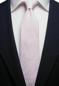 Marinblå kavaj med en vit skjorta under, prydd med en ljusrosa texturerad slips med ett subtilt mönster, knuten vid kragen.