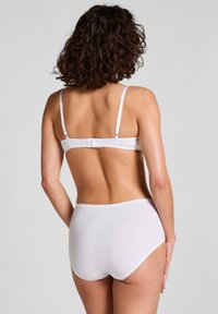 Weißes Dessous-Set mit einem schlichten weißen BH mit verstellbaren Trägern und einem Hakenverschluss, kombiniert mit hoch taillierten weißen Slips.