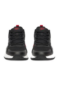 Mustad sportlikud tossud võrgust pealsega, kontrastsete punaste detailidega, paksu musta kummist tallaga ja ümmarguste paeltega. Keelal on Reeboki logo.