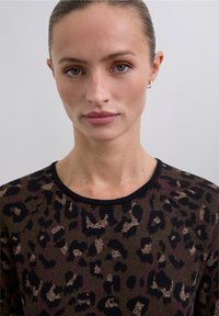 Suéter de punto con un patrón de leopardo en tonos marrón y burdeos con acentos negros. Tiene cuello redondo y tela texturizada.