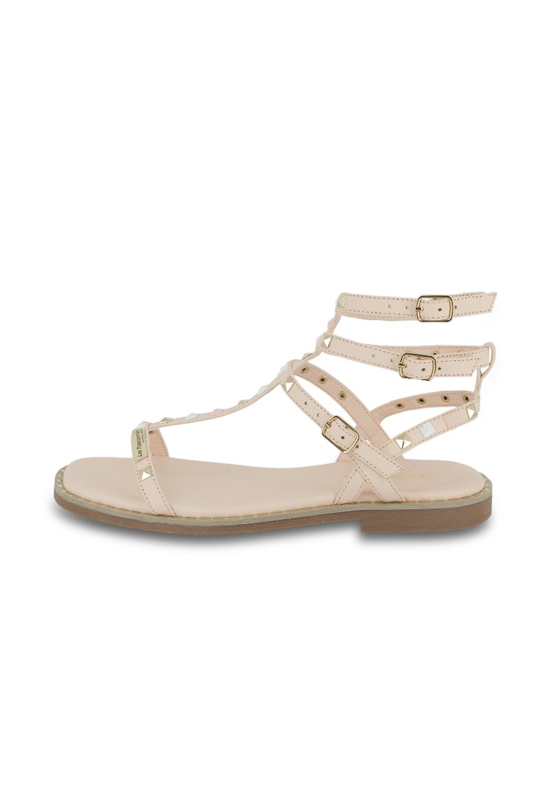 Sandalo a fascia di un delicato rosa pallido con tre fibbie regolabili, dettagli in metallo oro, suola piatta e finitura in pelle liscia.