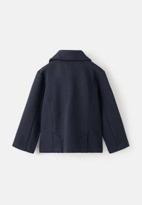 Palton bleumarin din amestec de lână, cu rever decupat, mâneci lungi și două buzunare laterale. Material texturat, cu o siluetă croită și scurtă.