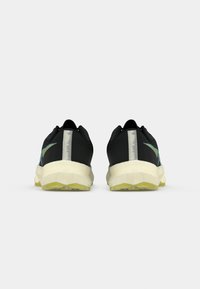 Sorte løbesko med mesh-overdel, der har akvamarine detaljer og en reflekterende stribe. Tyk, polstret sål med en gul gummisål.