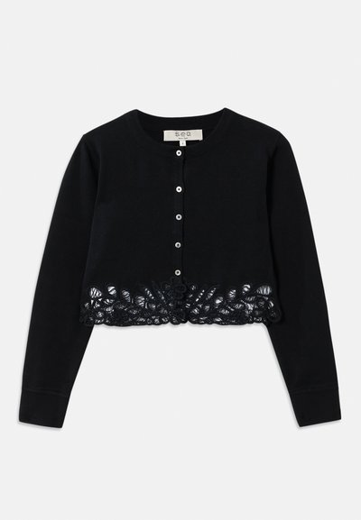 Juodas ilgas rankovėmis trumpas kardiganas su apvaliu iškirpimu, priekiniais mygtukais ir sudėtingomis gėlių nėrinio detalėmis palei apačią.