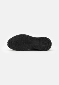 Zwart loop schoenen zool met een tekstuurontwerp. Bevat prominente noppen voor grip en stabiliteit. Het materiaal lijkt duurzaam en rubberachtig.