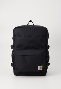 Mochila negra hecha de tela duradera, con dos bolsillos frontales con cremallera, bolsillos de malla en los laterales y una asa de transporte en la parte superior. Logo de la marca en el frente.