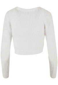 Pull blanc, cropped, à manches longues, en maille douce. Il présente un col rond et des poignets et un ourlet côtelés.