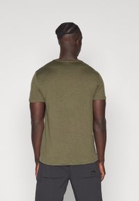 Olive green short-sleeve t-shirt with a crew neck, made from a textured fabric. Features a straight hem and minimal detailing at the back.