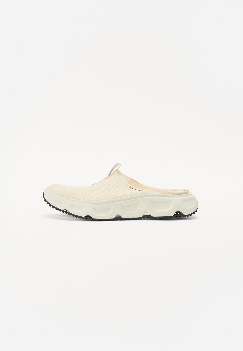 Krämfärgad nät slip-on sko med en tjock vit sula och svart texturerad yttersul. Har en dragflik vid hälen för enkel påtagning.