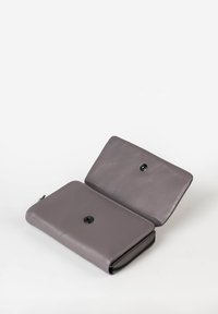Portafoglio in pelle grigia con texture liscia, forma rettangolare e chiusura a scatto nera. Presenta un compartimento con zip lungo un bordo.