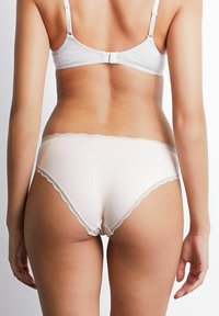 Låga trosor med spetsdetaljer i ljusbeige färg. Mjuk tygkvalitet med en slät yta, designad för komfort och diskret täckning.