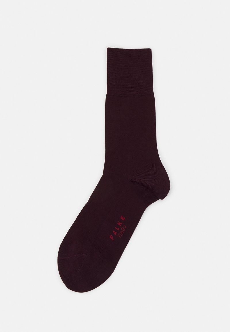 Calcetín burdeos hecho de un tejido suave, con un puño acanalado y un cuerpo liso y sin costuras. Logo bordado en rojo cerca del tobillo.