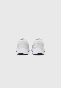 Sneaker bianche Nike con tomaia in mesh e suola in gomma. Presentano un logo sul tallone, numerosi fori di ventilazione e una finitura texture.
