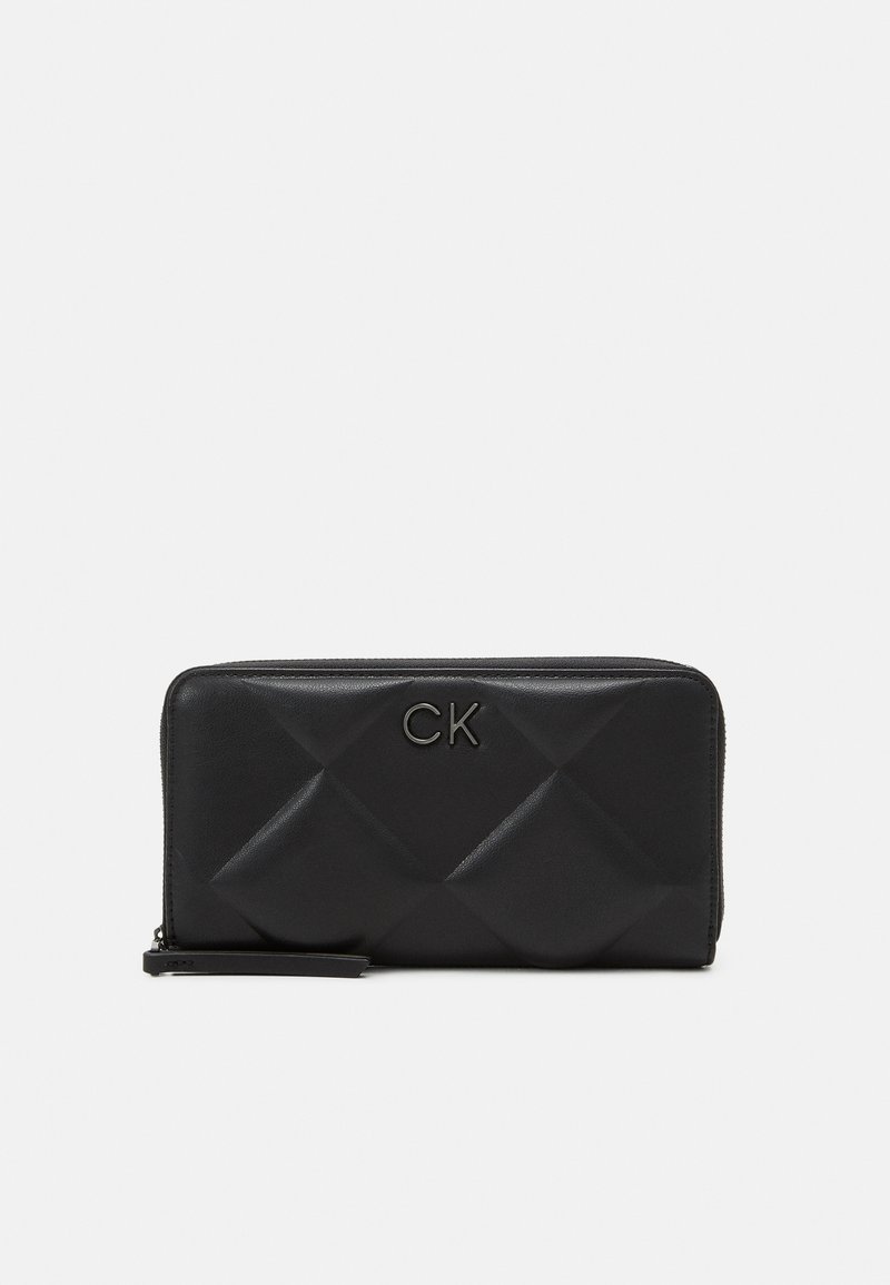 Black leather wallet featuring a quilted pattern with diamond-shaped accents and a silver CK logo. Zipper closure with a wrist strap.