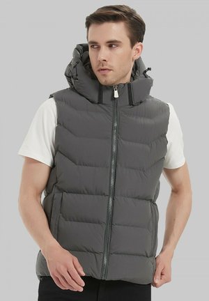 Gilet rembourré gris avec col montant et fermeture éclair à l'avant, doté de sections matelassées horizontales, de deux poches latérales et d'une capuche avec cordons de serrage.