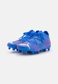 Scarpe da calcio blu con design a gradiente, tomaia testurizzata, accenti di logo bianchi e chiusura con lacci. Presenta diversi tacchetti per una migliore aderenza.