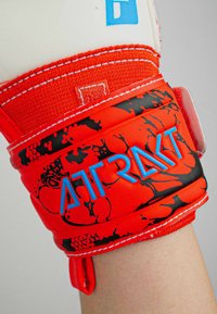 Rote Boxhandschuh mit strukturiertem Oberflächen, schwarzem abstraktem Muster, blauem "ATRAKT"-Logo und verstellbarem Handgelenkband für einen sicheren Sitz.