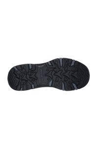 Suela de zapato de goma negra con un patrón de relieve rugged y diversas texturas y elementos elevados para un mejor agarre. Con el logo "SKECHERS" como acento.
