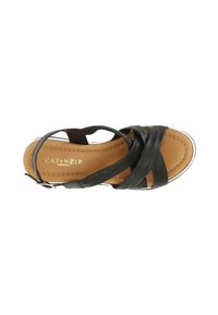 Sandal in pelle nera con design a fascia sovrapposta, soletta marrone, bordo della suola bianco e una piccola fibbia metallica per la regolazione.