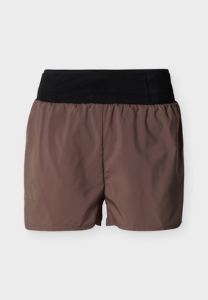 Shorts de sport marron avec une large taille élastique noire, tissu légèrement froncé et logo discret sur la partie inférieure de la jambe gauche.
