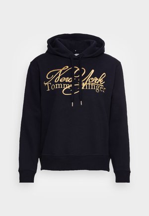 Marinblå huvtröja i bomull med guldtexten "New York Tommy Hilfiger" och en känguruficka framtill.