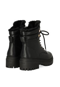 Zwarte leren enkellaarzen met een nepbontkraag, vetersluiting aan de voorkant en gouden hardwareaccenten. Dikke, robuuste zool voor grip.