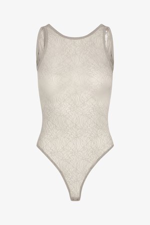Spetsbodysuit i ljusbeige med blommönster. Har en rundad halsringning och smala axelband. Slät struktur med en högskuren design på benet.