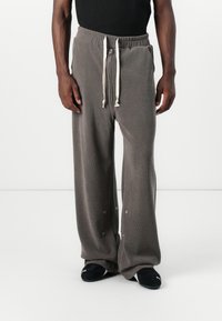 Gray wide-leg sweatpants made of soft fabric with an elastic waistband, drawstring, and snap details on the cuffs.