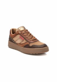 Zapatillas marrones y beige con una parte superior de cuero texturizado, detalles en oro y un logotipo rojo. Presenta una puntera redondeada y un collar acolchado.