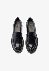 Mocasini din piele lăcuită neagră cu un design de profil redus, având o curea decorativă pe vamp și o tălpic texturat.