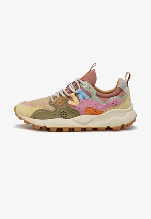 Multicolor suède en leren sneaker met een dikke beige zool, patroon van perforaties, gevoerde kraag, witte veters en aantreklussen op de tong en hiel.