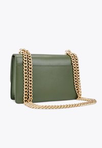 Borsa verde in ecopelle con una texture liscia, forma rettangolare e una tracolla in catena dorata. Presenta una tasca a scomparsa sul retro.