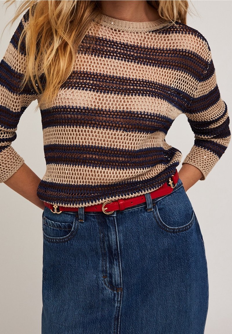Pull en maille mélangé coton avec des rayures horizontales beige et marine, col rond, et manches trois-quarts, associé à une ceinture rouge et une jupe en denim.