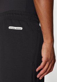 Black athletic shorts made of lightweight fabric, featuring an elastic waistband and a small "NATURAL VENTUS" logo on the right hip.