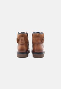Brune læder ankelstøvler med en struktureret overflade, udstyret med lynlås, kontrasterende blå foring og en stablet træsko.