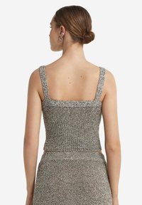 Grå och silverstickad kort topp med fyrkantig halsringning och tjocka band, som har en åtsittande textur och en sömlös avslutning vid fållen.