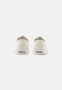 Canvas sneakers i ljusbeige med en texturerad yta. Har en vit gummisula och marinblå "Polo"-logotyp på hälen.