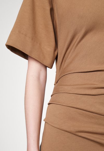 Brązowy, prążkowany top o luźnym kroju, z szerokimi, krótkimi rękawami i marszczonym detalem w talii, który nadaje mu teksturalny wygląd.