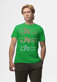 Groene katoenen t-shirt met bedrukte tekst in roze, wit en zwart met een race-thema. Korte mouwen en een klassieke pasvorm.