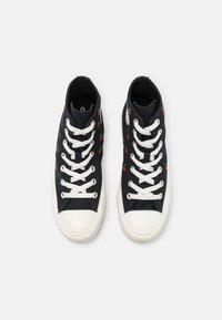 Sneakers high-top in tela nera con motivi di ciliegie rosse, lacci bianchi e punte in gomma. Tessuto texturizzato con suola liscia.