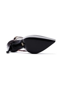 Black patent leather high-heeled shoe with a pointed toe and a slender, angular heel. Features a brown strappy accent.