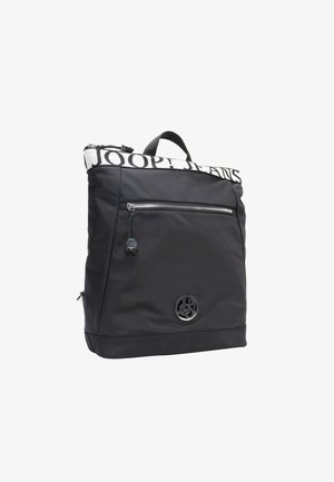 Zaino nero con un tessuto texturizzato, dotato di una tasca frontale con zip, spallacci regolabili e una toppa con logo. La parte superiore presenta una scritta in caratteri grandi.