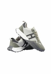 Zapatillas deportivas con parte superior de malla gris transpirable y acentos de ante verde, una media suela blanca y una suela exterior de goma negra texturizada.