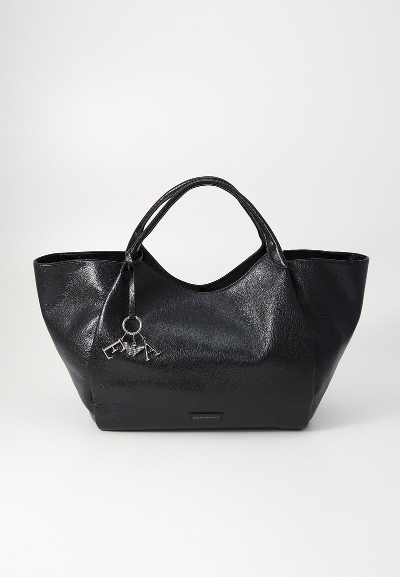 Melna tote soma, izgatavota no tekstūras materiāla; ar divām rokturiem, sudraba piekariņu un plakanu apakšu stabilitātei.