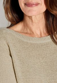 Maglione a maglia beige chiaro con un ampio collo a costine, caratterizzato da un motivo a trama aperta e tessuto che cade dolcemente.