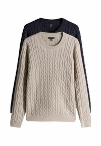 Dva džempera od pletene vune, jedan bež i jedan tamnoplavi, s okruglim izrezima i rebrastim manžetama, prikazani slojevito s teksturiranim uzorcima.