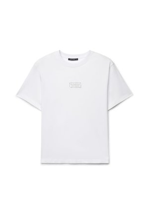 T-shirt bianca a maniche corte con scollo tondo e piccolo testo nero "professional Overthinker" centrato sul petto.