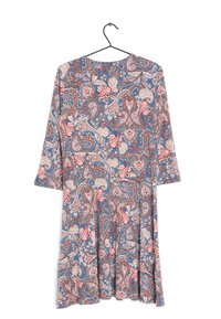 Pitkähihainen mekko sinisessä paisley-kuviossa, jossa on kukkakoristeita. Ominaisuuksiin kuuluu pyöreä pääntie ja leveä helma. Valmistettu kevyestä kankaasta.