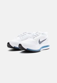 Adidași Nike albi pentru alergare, cu un material superior respirabil, logo-ul swoosh gri, talpă amortizată, accente ale talpii intermediare albastre și outsole din cauciuc texturat negru.
